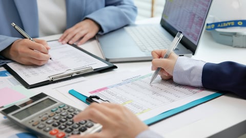 Expert woman reviewing data and preparing cost variance report at audit office